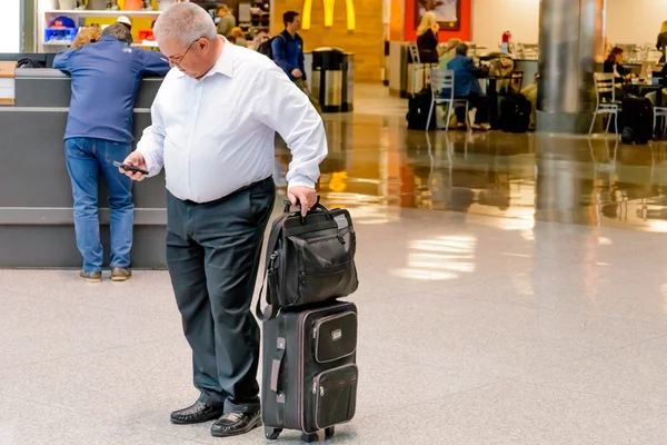 Menschen, die mit Gepäck auf einem Flughafen gehen — Stockfoto