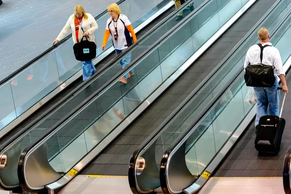 People walking with luggage in airport — Stock Photo, Image