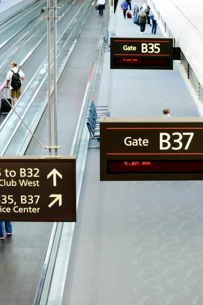 People walking with luggage in airport — Stock Photo, Image