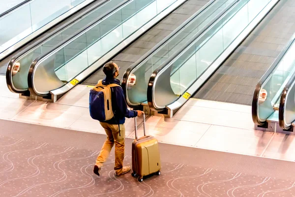 People walking with luggage in airport — Stock Photo, Image