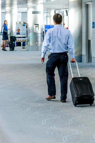 People walking with luggage in airport — Stock Photo, Image