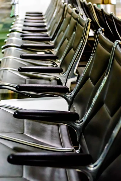 Posti a sedere all'aeroporto vuoti - sedie nere tipiche in attesa di imbarco — Foto Stock