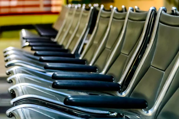 Asientos vacíos del aeropuerto - sillas negras típicas en espera de embarque —  Fotos de Stock