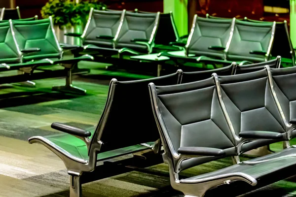 Asientos vacíos del aeropuerto - sillas negras típicas en espera de embarque —  Fotos de Stock