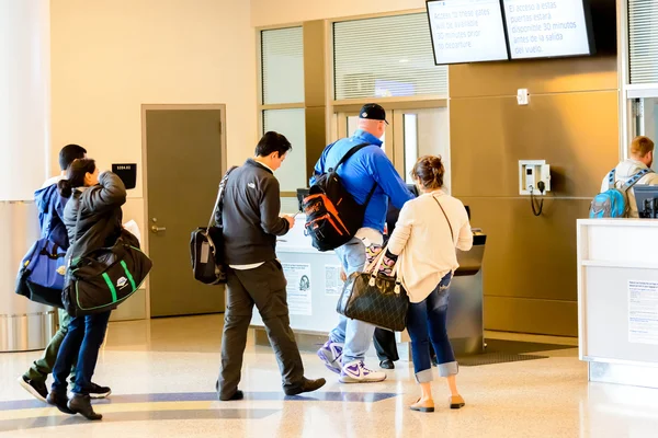 Pasajeros en cola para embarcar en la puerta de embarque — Foto de Stock