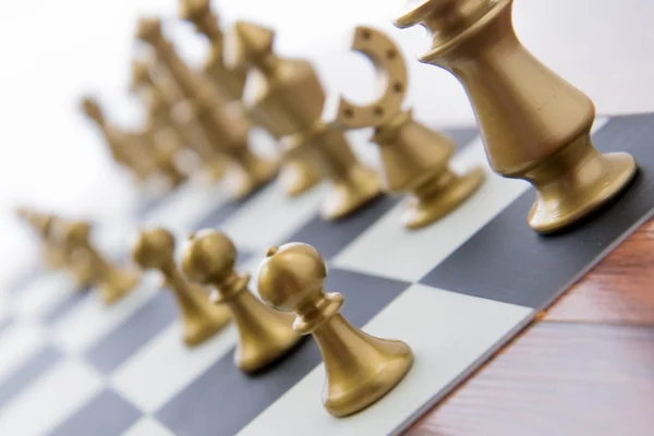 Chess game - gold playing pieces lined up on chessboard — Stock Photo, Image