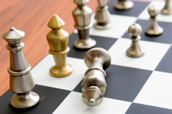 Partita a scacchi - re d'argento caduto sulla scacchiera — Foto Stock