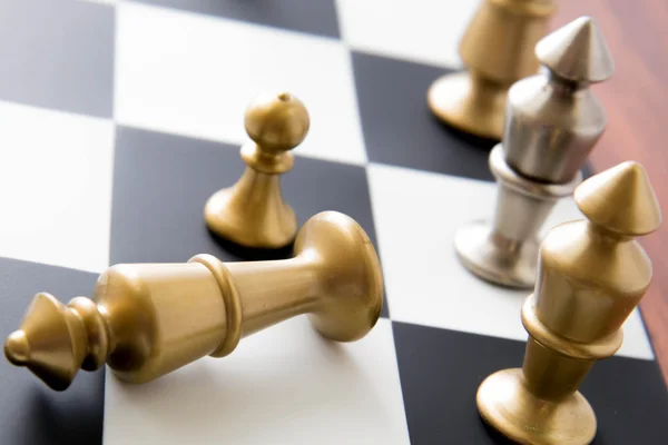 Schackspel - fallna guld kung på schackbrädet — Stockfoto
