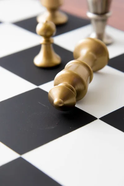 Schackspel - fallna guld kung på schackbrädet — Stockfoto