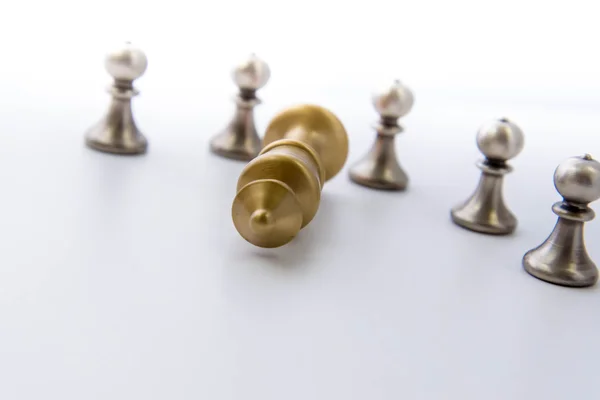 Jogo de xadrez - peões circulados em torno de um rei caído — Fotografia de Stock