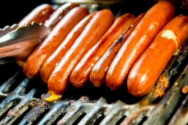 hotdogs sizzling on the outdoor grill