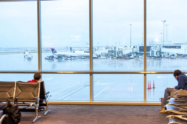 Pasajeros sentados con equipaje en el aeropuerto — Foto de Stock