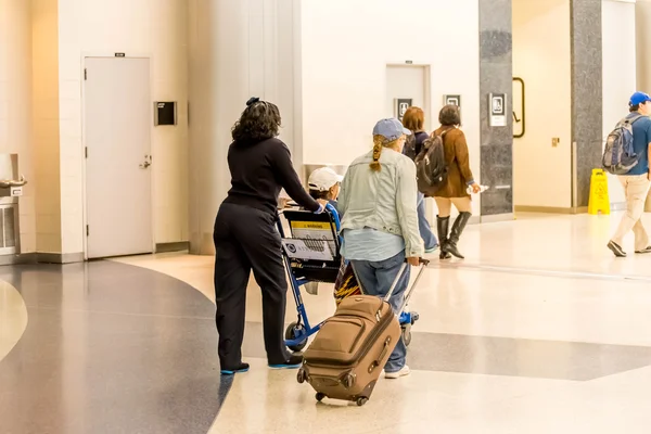 Pasajeros caminando con equipaje en el aeropuerto —  Fotos de Stock