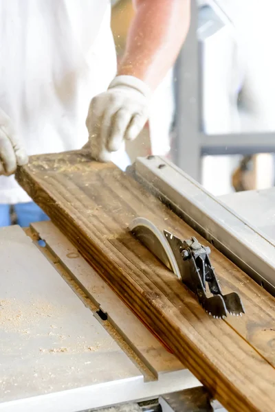 Uomo tavolo da lavoro in legno sega con mani e guanto — Foto Stock