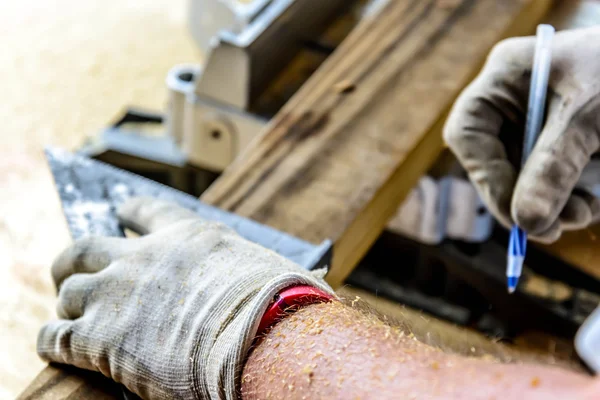 Man trä arbetsbord såg med händer och handske — Stockfoto