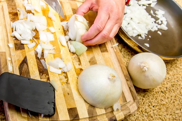 Cook chopping a white onion