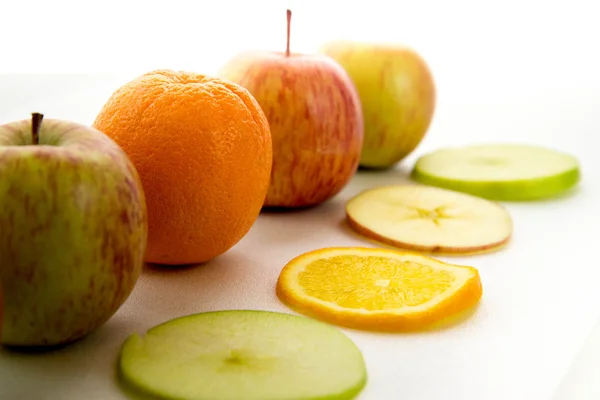 Line of apples and slices with one orange — Stock Photo, Image