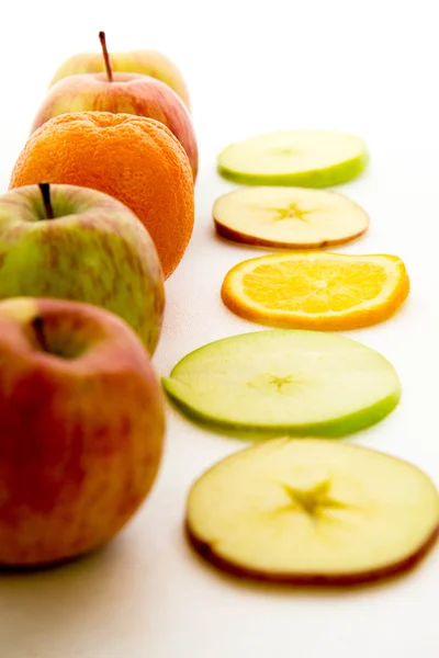 Γραμμή μήλα και φέτες με ένα πορτοκάλι — Φωτογραφία Αρχείου