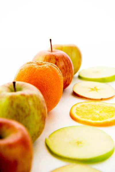 Line of apples and slices with one orange — Stock Photo, Image