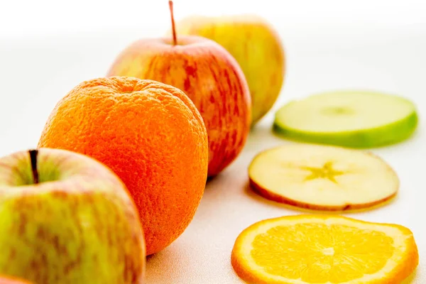 Line of apples and slices with one orange — Stock Photo, Image