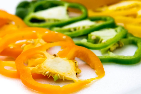 Rood, groen, geel en oranje paprika segmenten — Stockfoto