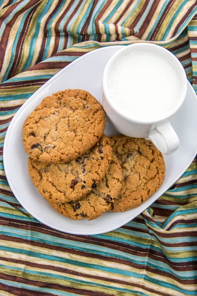 Galletas de avena con pasas y taza de leche —  Fotos de Stock