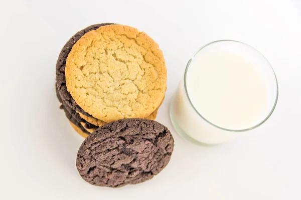 Biscoitos de chocolate e açúcar empilhados com copo de leite — Fotografia de Stock