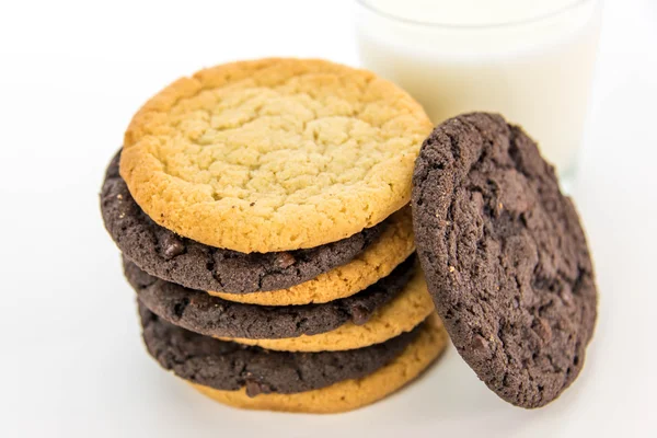 Galletas de chocolate y azúcar apiladas con un vaso de leche —  Fotos de Stock