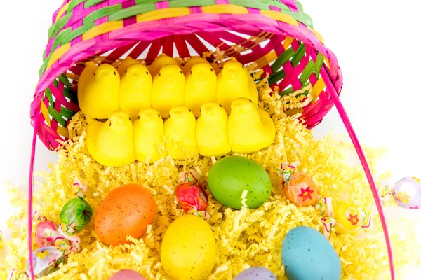 Cesta de Pascua con huevos de colores, pollitos amarillos y dulces — Foto de Stock