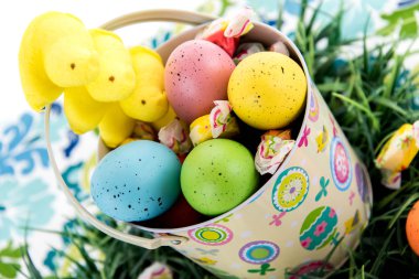 Renkli yumurta, şeker ve sarı civciv easter kova