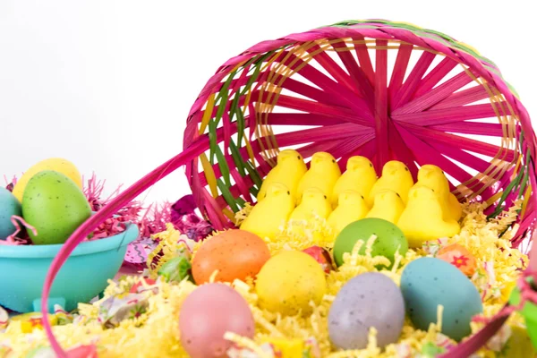 Cesta de Pascua con huevos de colores, pollitos amarillos y dulces — Foto de Stock