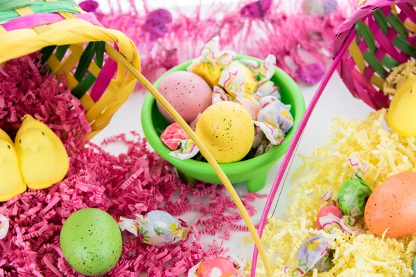 Cesta de Pascua con huevos de colores, pollitos amarillos y dulces — Foto de Stock