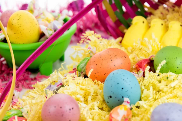 Cesta de Páscoa com ovos coloridos, pintinhos amarelos e doces — Fotografia de Stock