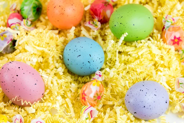 Easter basket with colored eggs, yellow chicks and candy — Stock Photo, Image