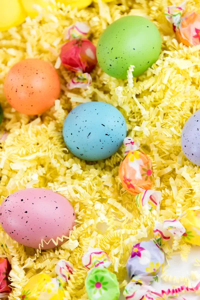 Uova di Pasqua colorate e caramelle — Foto Stock