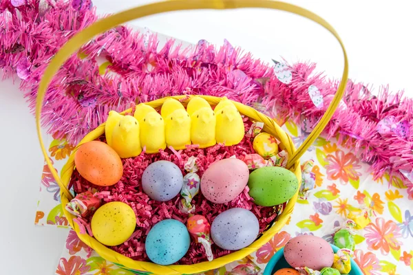 Cesta de Pascua con huevos de colores, pollitos amarillos y dulces — Foto de Stock