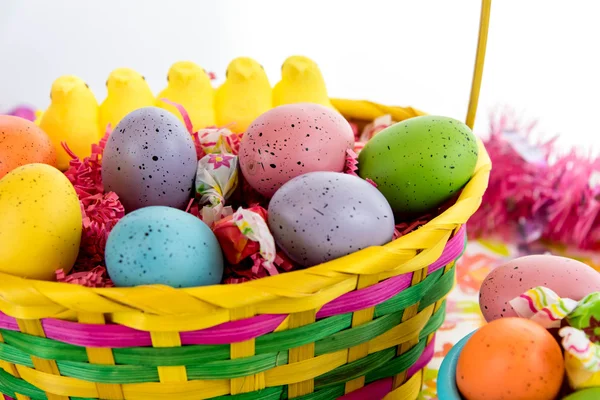 Kosz wielkanocny z kolorowych jaj, żółty piskląt i słodycze — Zdjęcie stockowe