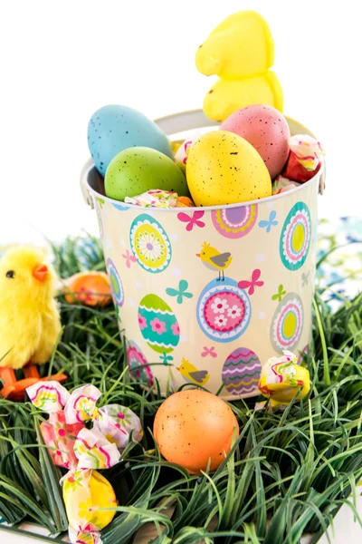 Ostereier mit bunten Eiern, Bonbons und gelben Küken — Stockfoto