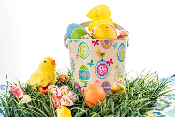 Ostereier mit bunten Eiern, Bonbons und gelben Küken — Stockfoto