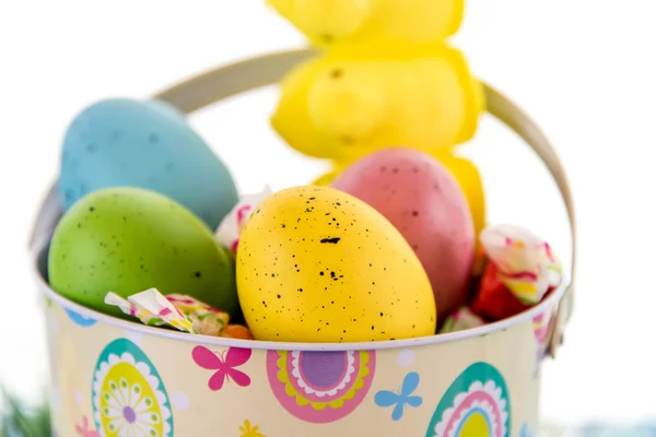 Ostereier mit bunten Eiern, Bonbons und gelben Küken — Stockfoto