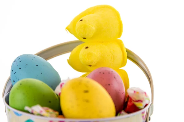 Easter bucket with colored eggs, candy and yellow chicks — Stock Photo, Image