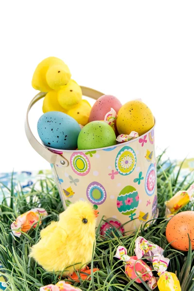 Easter bucket with colored eggs, candy and yellow chicks — Stock Photo, Image