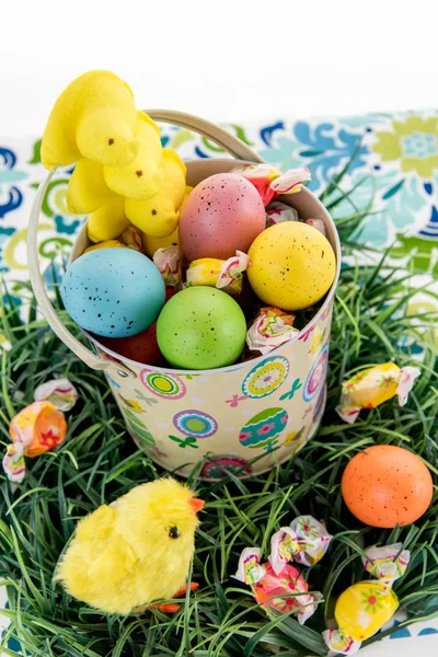 Ostereier mit bunten Eiern, Bonbons und gelben Küken — Stockfoto