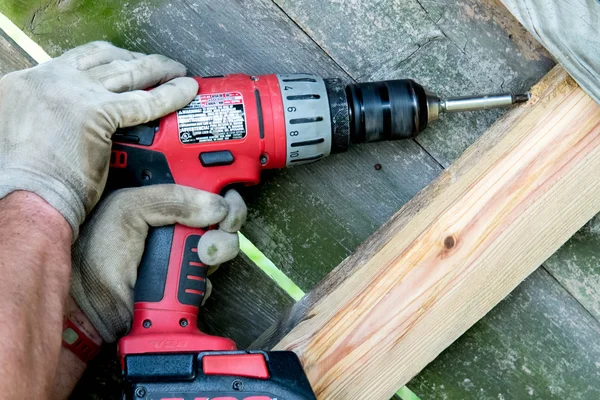 Man borra hål för trä staket reparation — Stockfoto