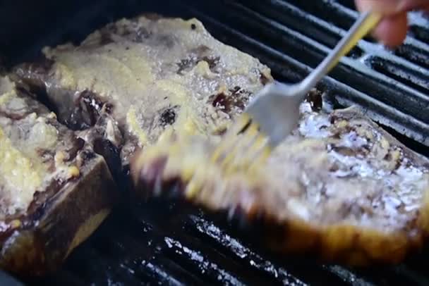 Knoblauchkrustensteaks, die auf dem Grill grinsen und brutzeln — Stockvideo