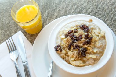 suyu ve bir tabak yulaf ezmesi badem dilimleri ve kuru üzüm ile