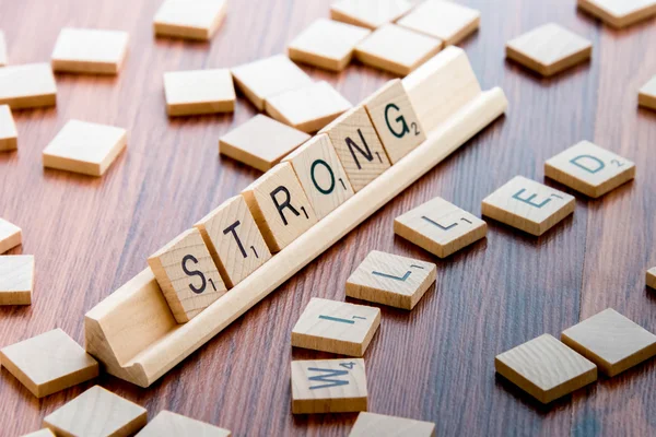 Scrabble Word Gioco piastrelle di legno ortografia STRONG WILLED — Foto Stock