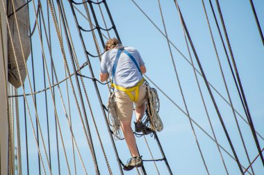 adam bir yelkenli üzerinde bir ip Merdiven tırmanma
