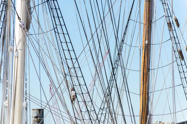 Sailboat masts, riggin and rolled up sails — Stock Photo, Image