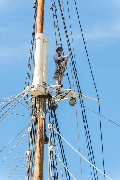 Mann som arbeider på høyder på seilbåtmast – stockfoto